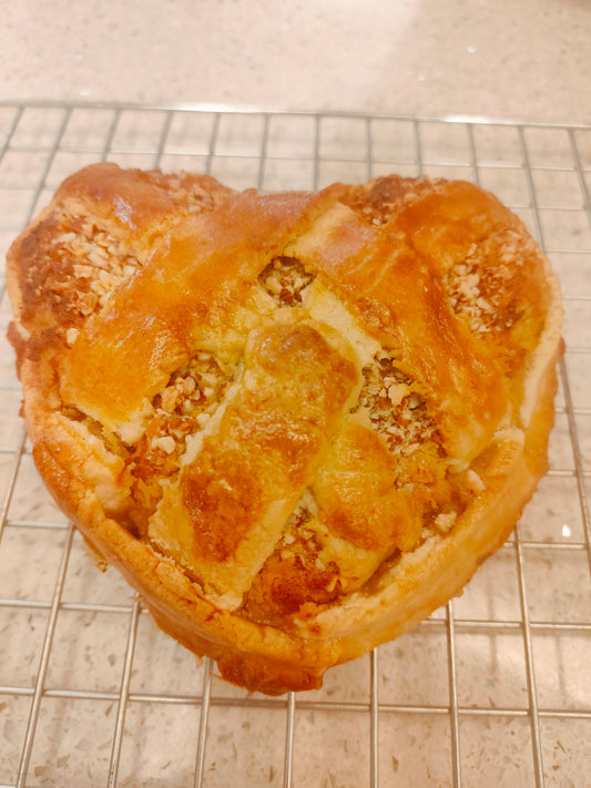 Heart-shaped banana pie with golden crust and nutty top
Pai pisang berbentuk hati dengan kerak keemasan dan taburan kacang